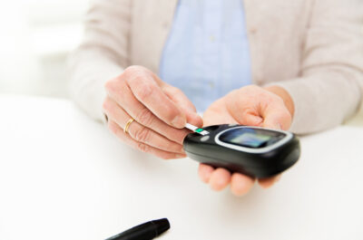 senior woman with glucometer checking blood sugar