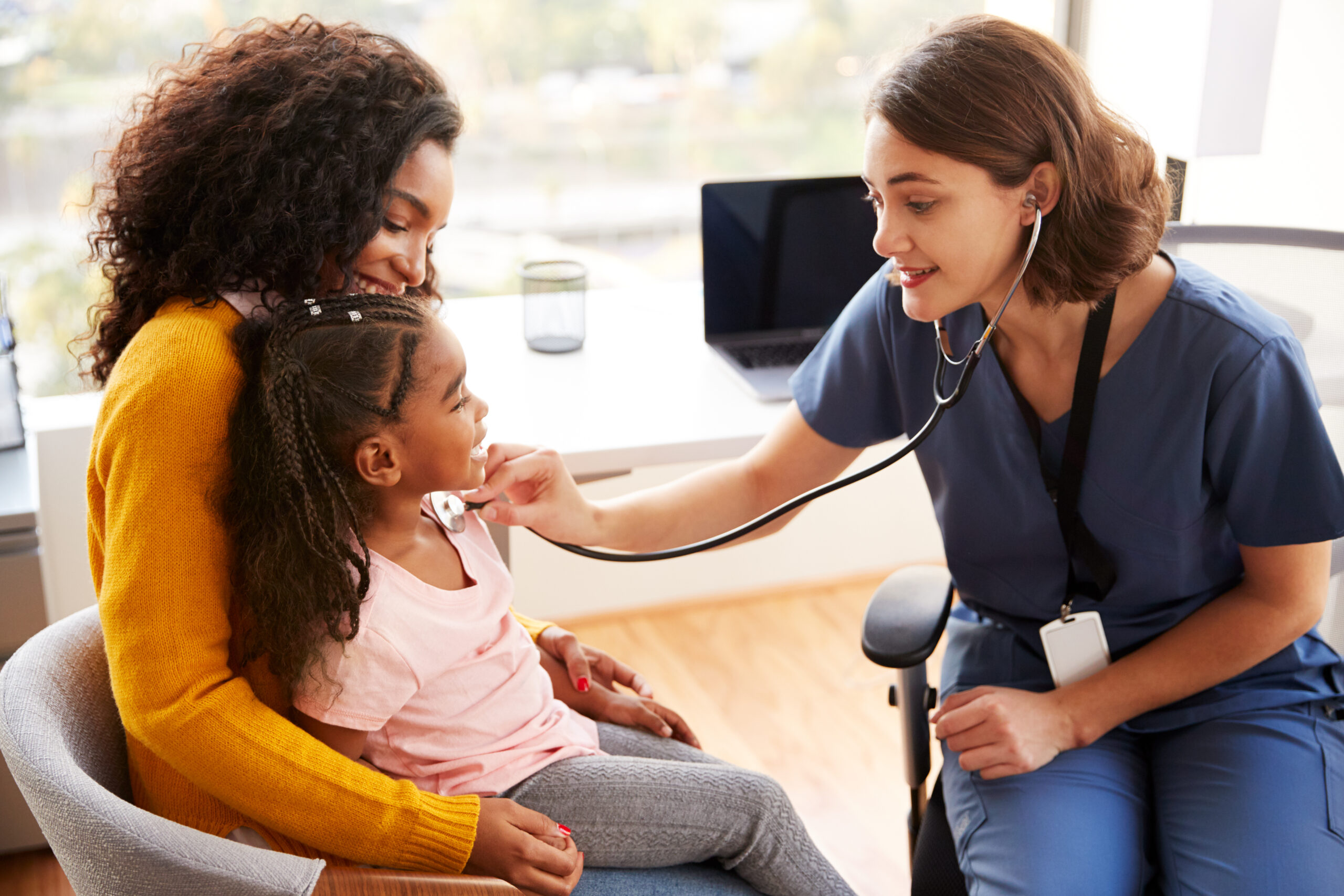 Female,Pediatrician,Wearing,Scrubs,Listening,To,Girls,Chest,With,Stethoscope