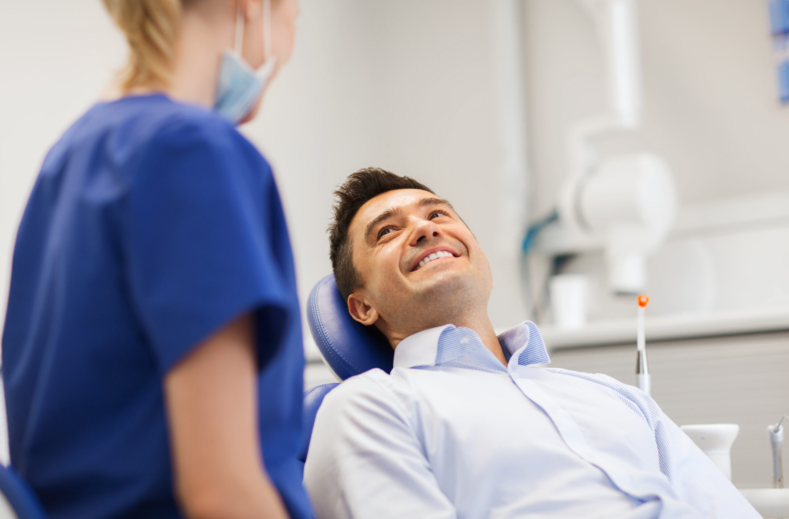 Female,Dentist,With,Happy,Male,Patient,At,Clinic