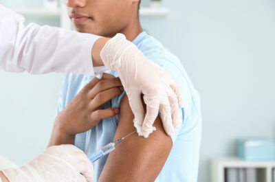 Doctor,Vaccinating,Teenage,Boy,In,Clinic,,Closeup